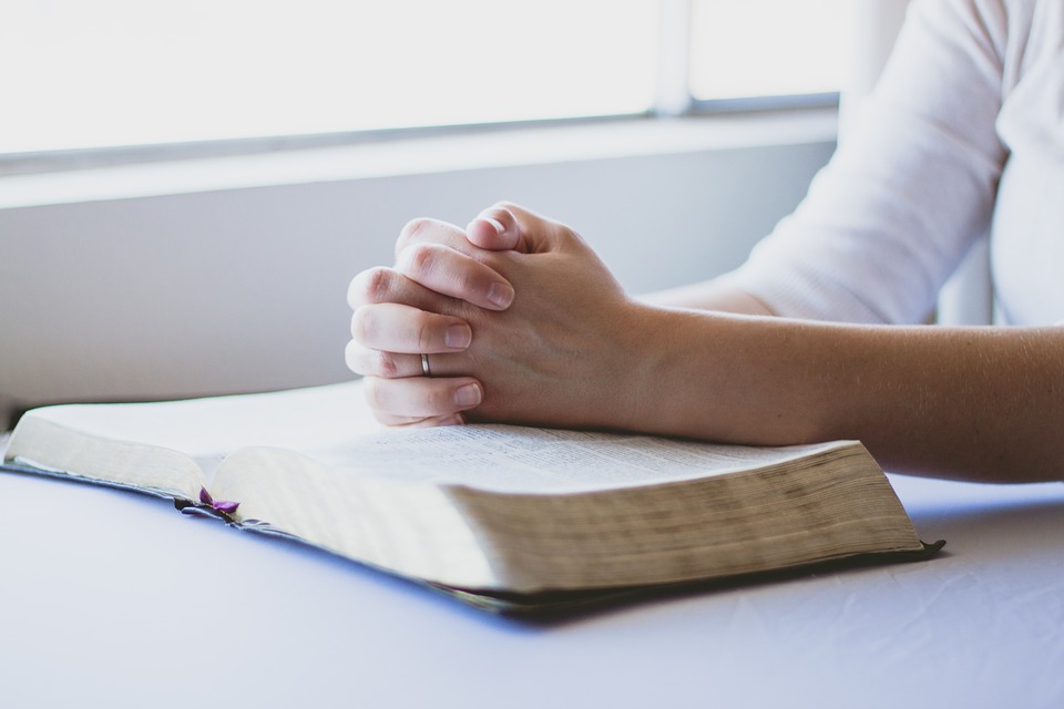 woman praying with bible